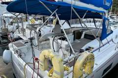 2024 Beneteau Oceanis 46.1 yacht with blue canopy, docked at marina.