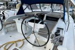 2024 Beneteau Oceanis 46.1 yacht cockpit with steering wheel and seating area.