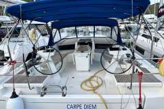 2024 Beneteau Oceanis 46.1 yacht cockpit with dual steering wheels and blue canopy.