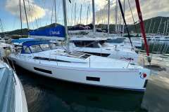 2024 Beneteau Oceanis 46.1 sailboat docked in marina, featuring sleek design and blue canopy.