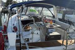 2017 Beneteau Oceanis 48 yacht cockpit with table, flowers, and nautical equipment.
