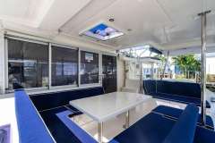Spacious interior of 2016 Leopard 40 catamaran with blue seating and white table.