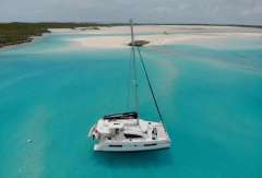 Leopard 40 catamaran sailing in turquoise waters near sandy beach, 2020 model.