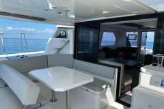 Luxurious 2022 Leopard 42 yacht interior with ocean view, featuring modern seating and dining area.