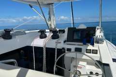 Cockpit of 2022 Leopard 42 catamaran with navigation equipment and ocean view.