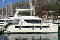2024 Leopard 40 Powercat yacht docked in a marina with mountainous backdrop.