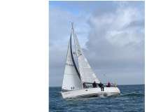 Sailboat "Feeling 32 DI" from 2010 navigating ocean waters under cloudy skies.