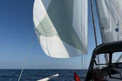 Sailboat Feeling 32 DI 2010 with sails unfurled on open sea under clear blue sky.