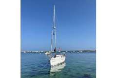 Sailboat "Feeling 32 DI" 2010 model anchored in clear blue waters under a sunny sky.