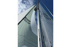 Sailboat mast and sails against blue sky, Feeling 32 DI, 2010 model.