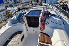 2006 Dufour 40 Performance sailboat deck with ropes and wooden seating in marina.