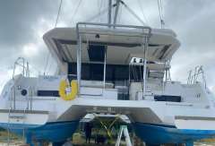 2020 Leopard 45 catamaran on land, undergoing maintenance with tools and ladders.