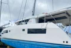 2020 Leopard 45 catamaran on dry dock, white hull with blue bottom, overcast sky.