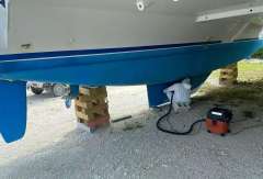 Leopard 45 catamaran on blocks, undergoing maintenance, with vacuum cleaner nearby.