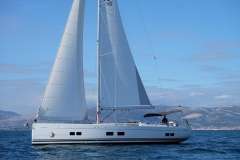 Sailing yacht Hanse 588, 2017 model, cruising on open water with mountains in the background.