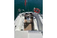 Cockpit view of 1983 Jeanneau Espace 1000 sailboat with wooden deck and steering wheel.