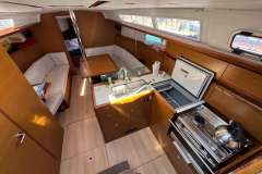 Interior of 2020 Jeanneau Sun Odyssey 389 yacht, featuring kitchen and seating area.