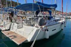 2020 Jeanneau Sun Odyssey 389 sailboat docked in a marina, featuring a blue canopy.