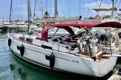 2019 Hanse 508 yacht docked in marina with red canopy and sleek design.