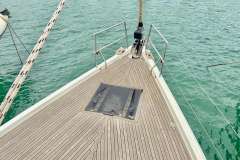 Bow of 2019 Hanse 508 yacht with teak deck, sailing on calm waters.
