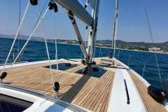 2019 Hanse 508 yacht sailing on blue ocean near coastline.