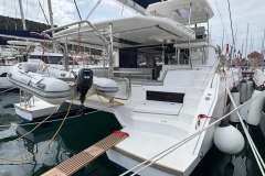 2020 Leopard 45 catamaran docked with dinghy and outboard motor, marina setting.
