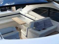 Luxurious seating area on a 2012 Sunseeker Portofino 48 yacht with cushions and table.