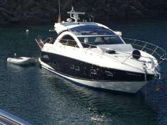 2012 Sunseeker Portofino 48 yacht anchored in clear blue water.