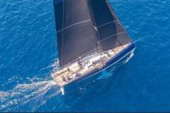 Aerial view of 2019 Nautor Swan Club Swan 50 sailing on clear blue water.
