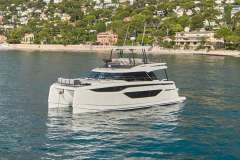 Manufacturer Provided Image: 2024 Prestige M48 yacht cruising near a scenic coastal town.