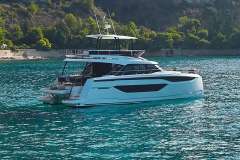 Manufacturer Provided Image: 2024 Prestige M48 yacht cruising on turquoise waters near a lush coastl