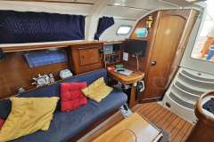 Interior of 2002 Beneteau Oceanis Clipper 311 yacht with cozy seating and navigation area.